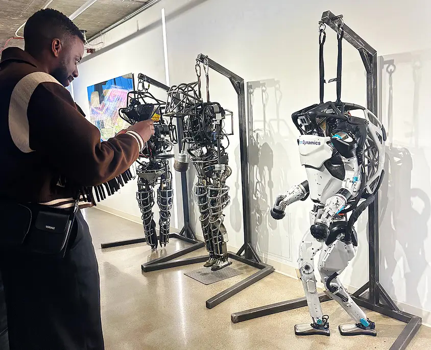 John Imah photographing humanoid robots in a technology lab