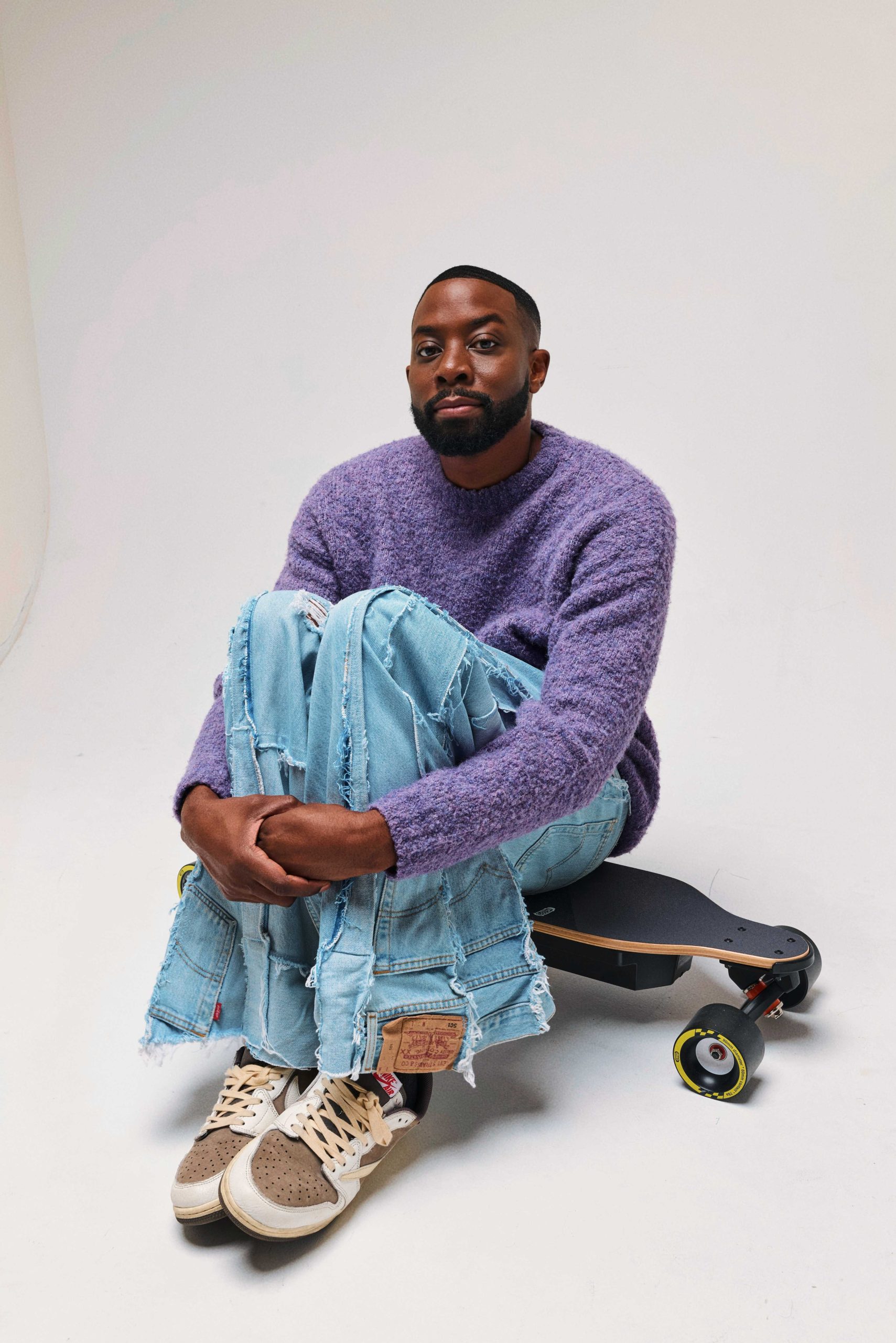 John e Imah fotografati per Galore accanto a uno skateboard