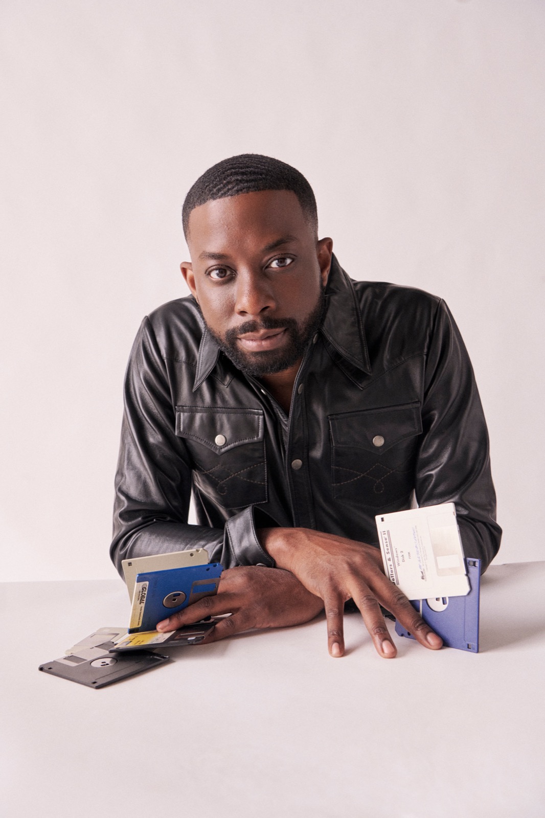 John Imah photographed with vintage floppy disks